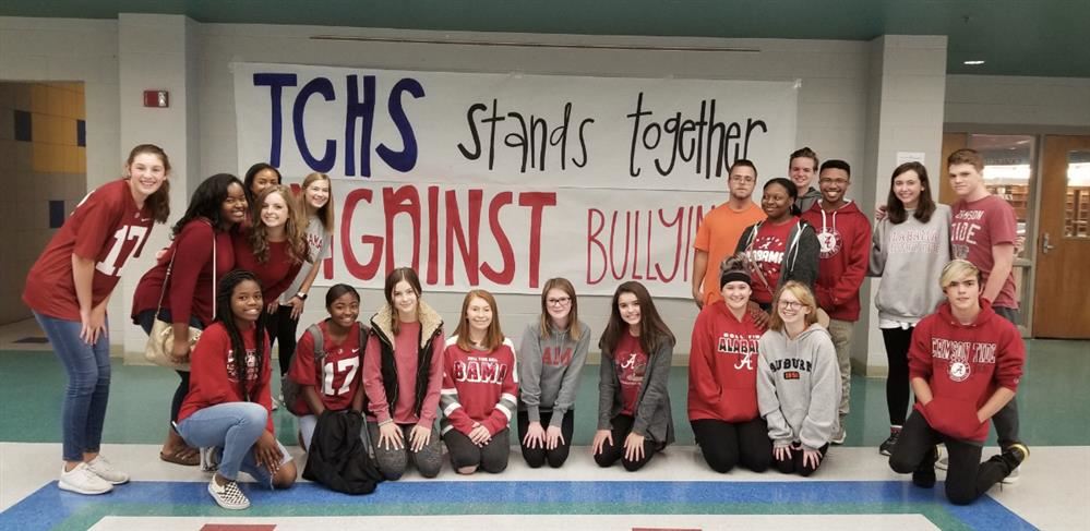 Students dressed for team colors day with bullying prevention sign in background. Students dressed for team colors day with bullying prevention sign in background.