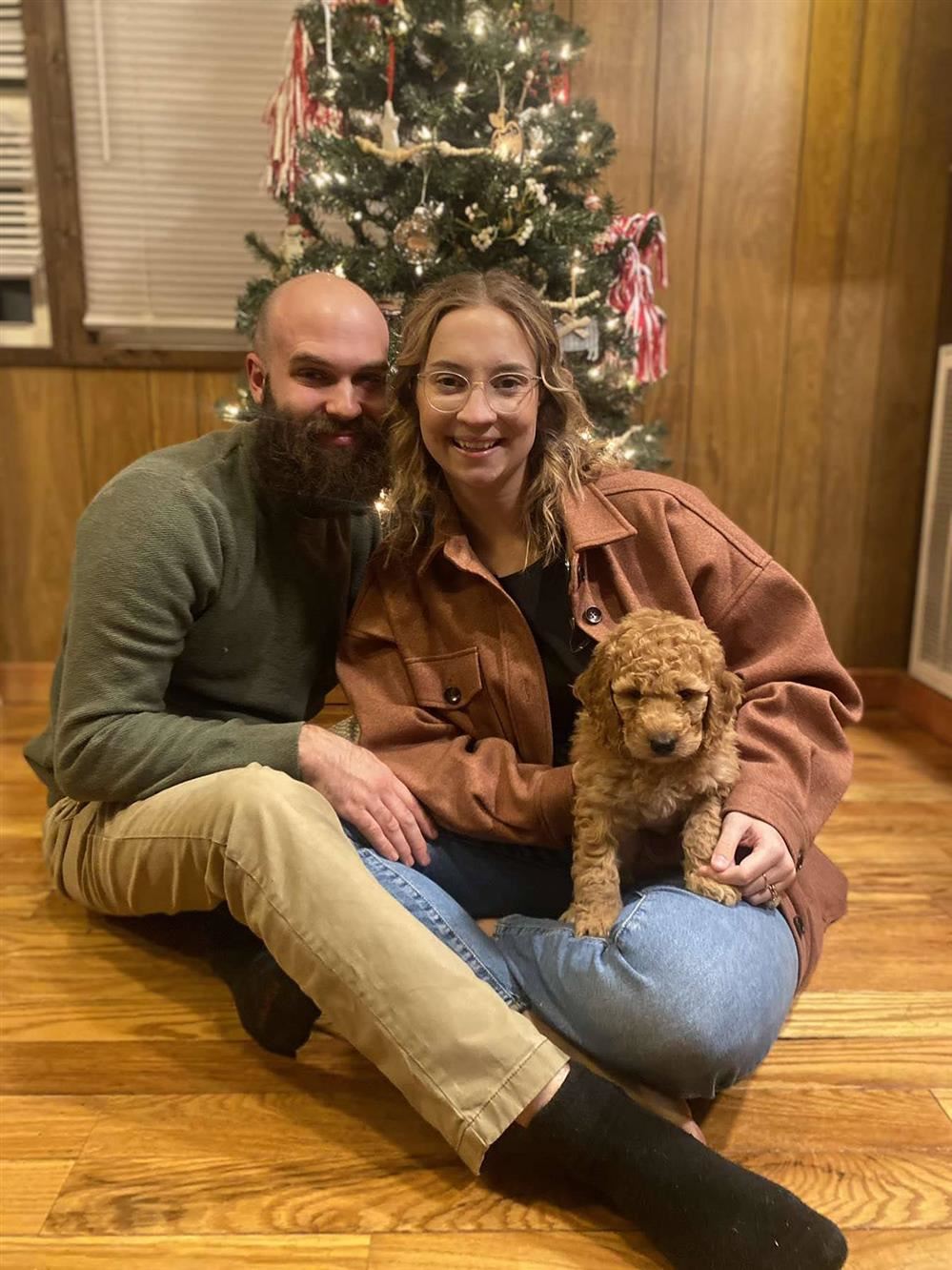 Owen, Mrs. Davis, and Wren sitting in front of a Christmas tree.