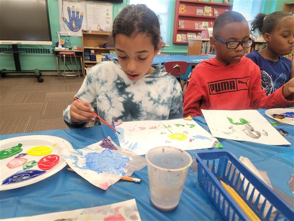 Emerging Super Leaders are enjoying a cookie and painting party for meeting their 3rd Nine Week Accelerated Reading Goals! Showing Unity, these 3rd and 4th grade students work together.